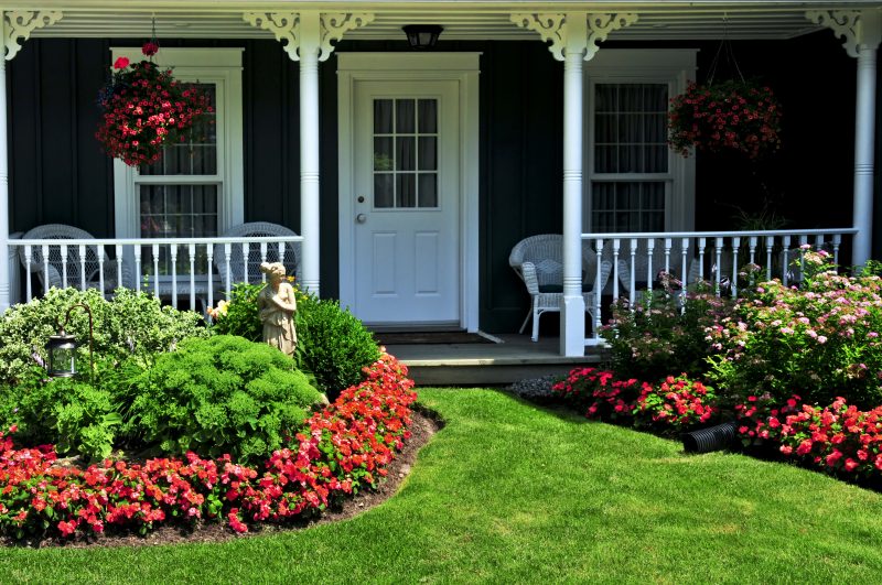 Landscaped front yard with flowers and green lawn