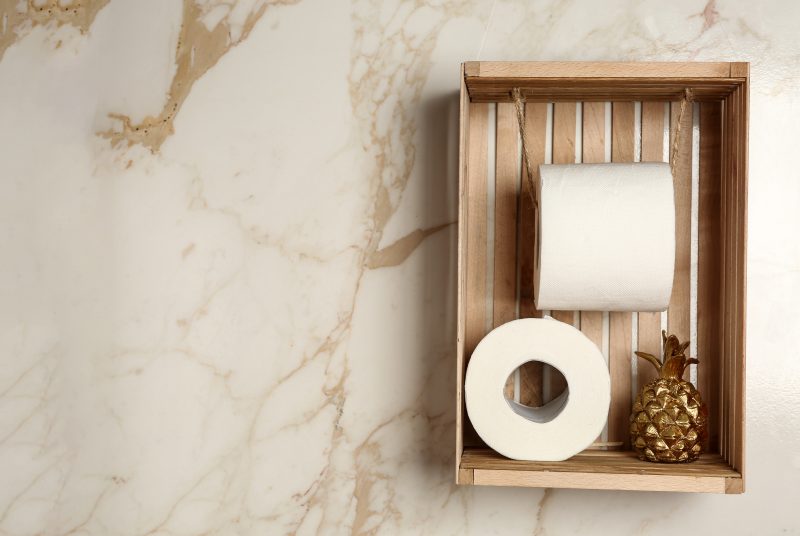 Rolls of toilet paper with decor on light wall