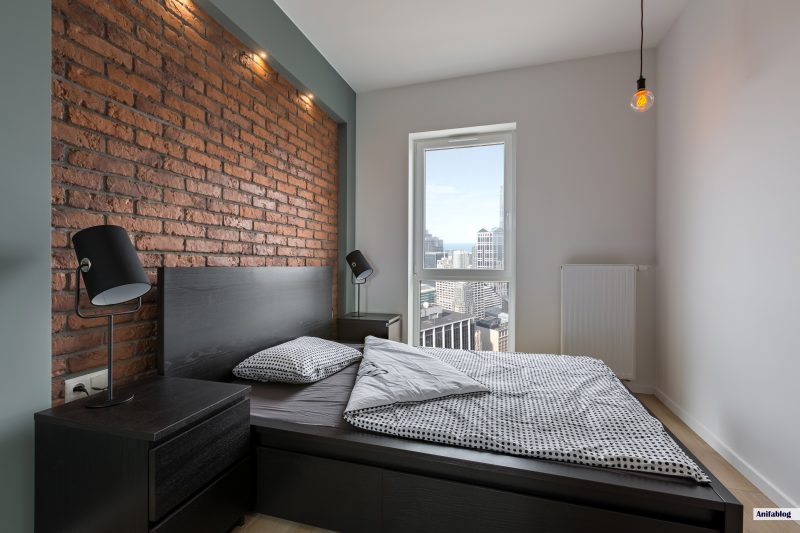 Industrial style bedroom with red, brick wall